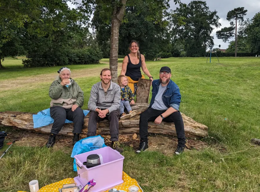 4 volunteers and a small child sitting down, drinking tea and talking about how to improve Druids Heath